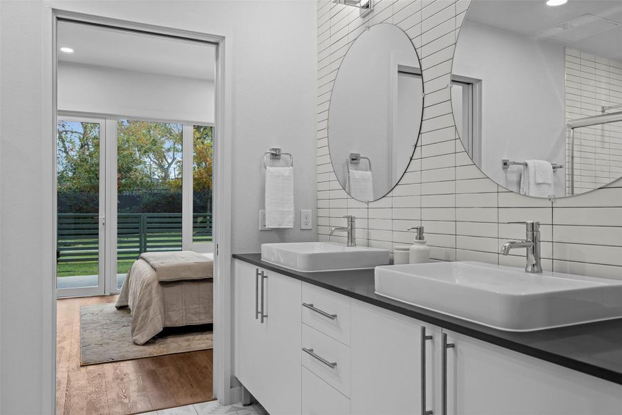 Full bathroom with double vanity, decorative backsplash, a sink, and wood finished floors