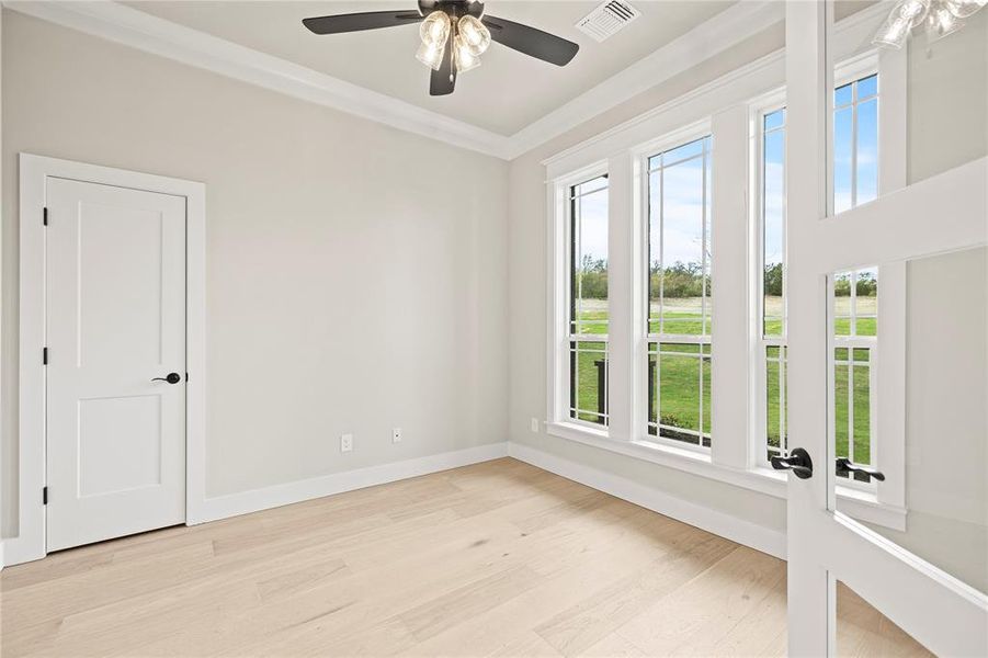 Empty room with light wood-type flooring, crown molding, and ceiling fan Empty room with light wood-type flooring, crown molding, and ceiling fan