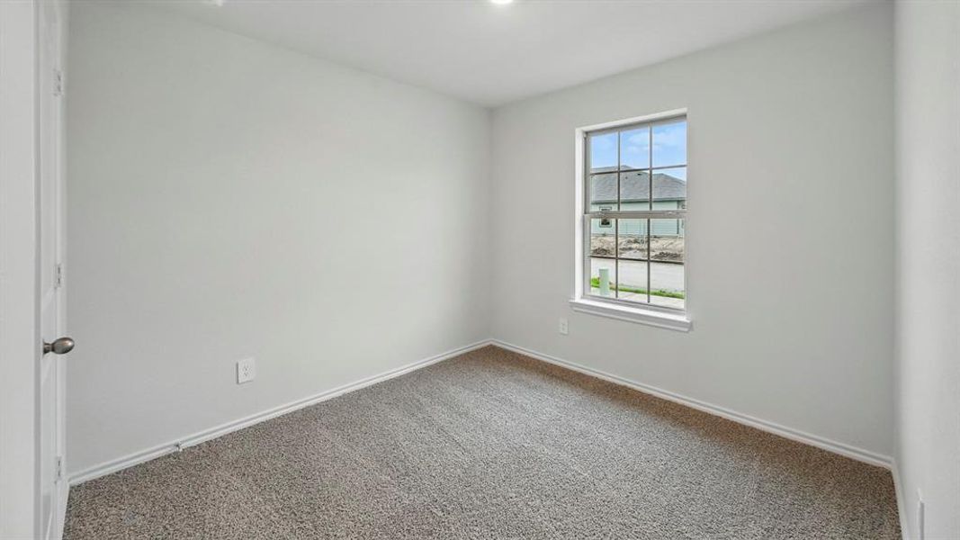 This room features neutral-toned carpet, light-colored walls, and a window providing natural light