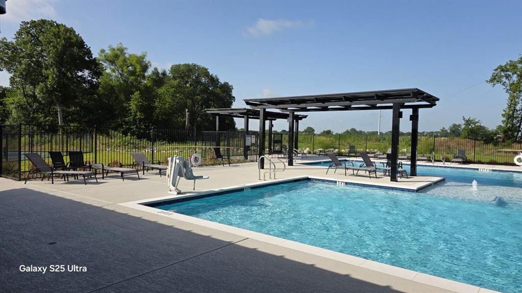 Resort-style pool area featuring multiple swimming pools, concrete decking, and two pergolas providing shaded seating Resort-style pool area featuring multiple swimming pools, concrete decking, and two pergolas providing shaded seating