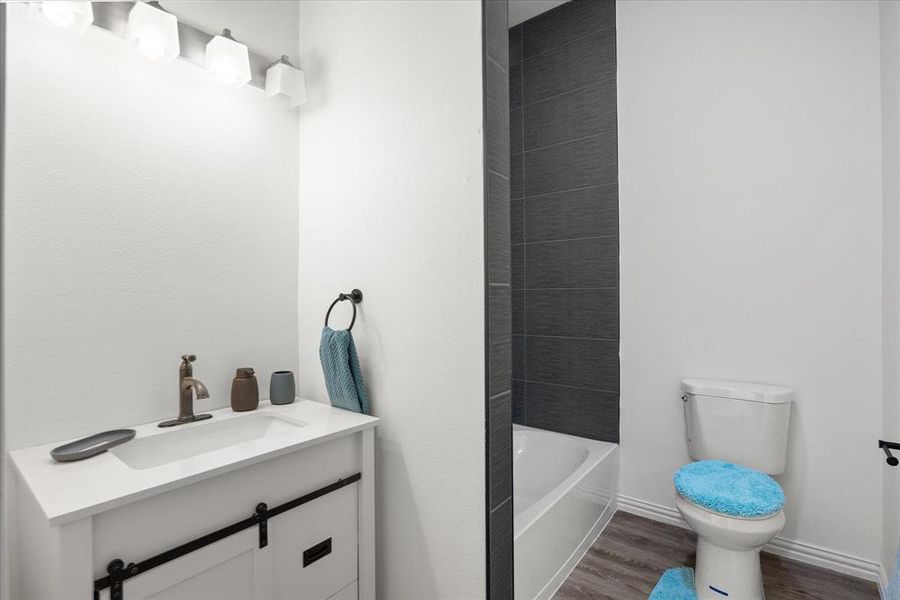 Bathroom with hardwood / wood-style flooring, vanity, and toilet