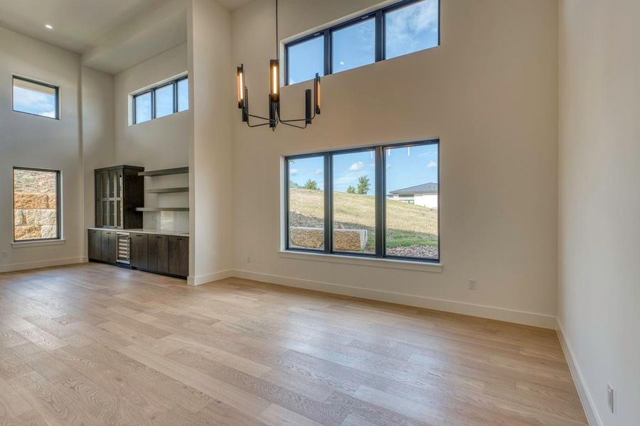 Double-height ceilings and a dramatic wall of windows define this light-filled open living space. Double-height ceilings and a dramatic wall of windows define this light-filled open living space.