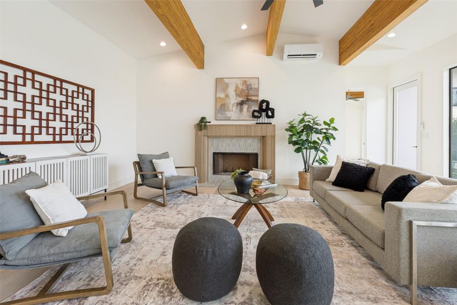 Natural light floods this inviting living and dining area, showcasing exposed beams and a serene outdoor vista.