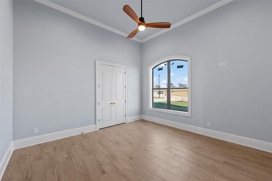 Unfurnished room featuring ornamental molding, wood finished floors, and ceiling fan Unfurnished room featuring ornamental molding, wood finished floors, and ceiling fan