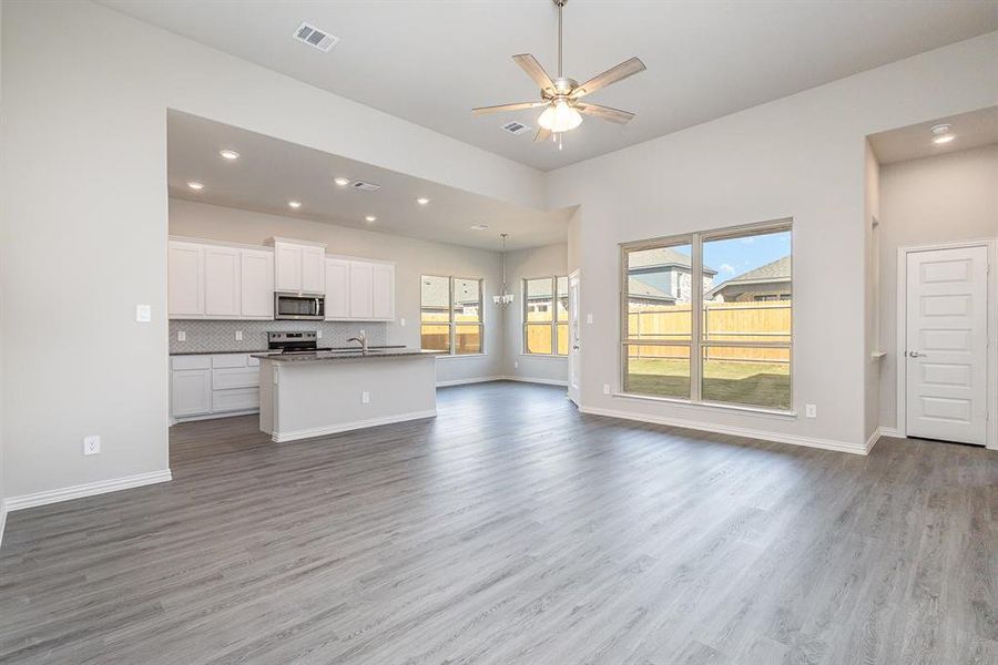 Unfurnished living room with hardwood / wood-style flooring, ceiling fan, and sink