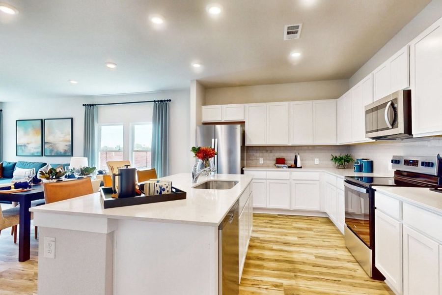 A kitchen with white cabinets.