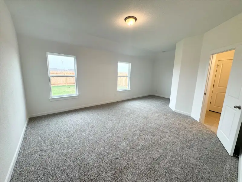 Unfurnished room with light colored carpet and a textured ceiling