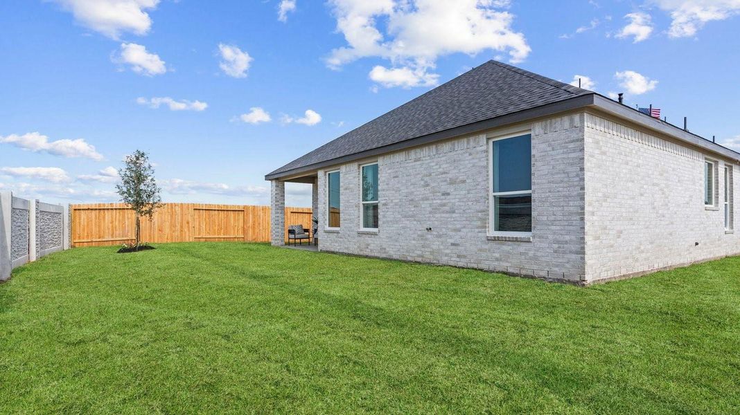 Large fenced-in backyard with a covered patio, perfect for outdoor entertaining.