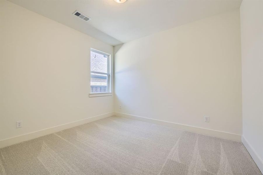 Unfurnished room featuring light colored carpet, visible vents, and baseboards