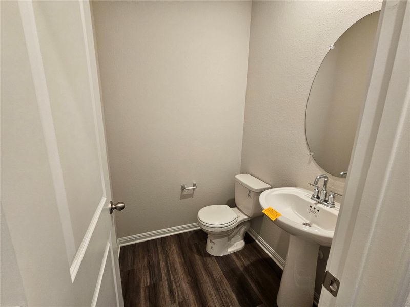Bathroom featuring dark wood-style flooring and a textured wall Bathroom featuring dark wood-style flooring and a textured wall
