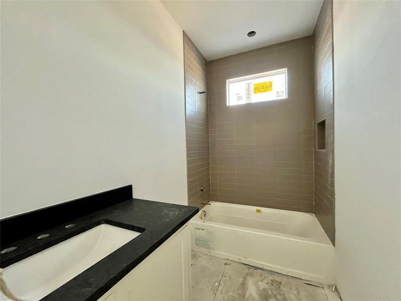 Bathroom featuring vanity and tiled shower / bath