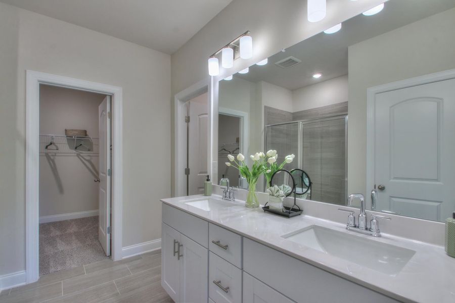 The primary bathroom features dual vanity sinks and a large walk-in closet.