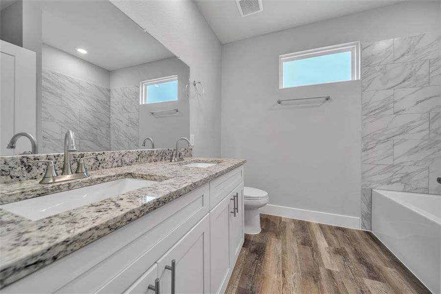 Bathroom featuring vanity, hardwood / wood-style flooring, and toilet