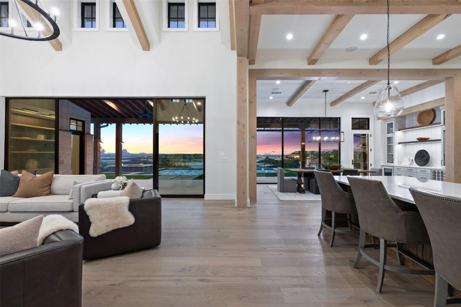 Living room featuring beamed ceiling, a chandelier, light wood finished floors, and recessed lighting