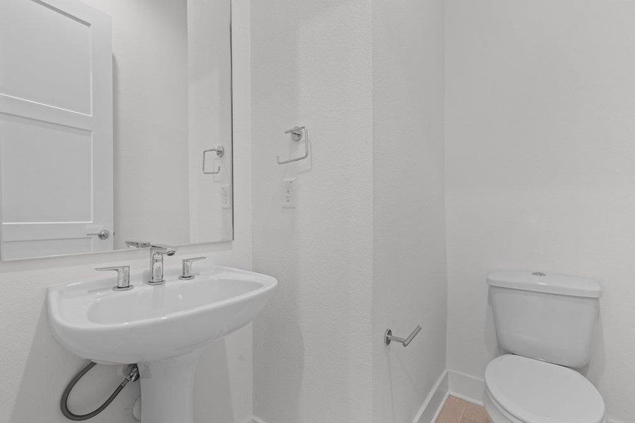 A crisp white powder room features a classic pedestal sink and polished chrome hardware. A crisp white powder room features a classic pedestal sink and polished chrome hardware.