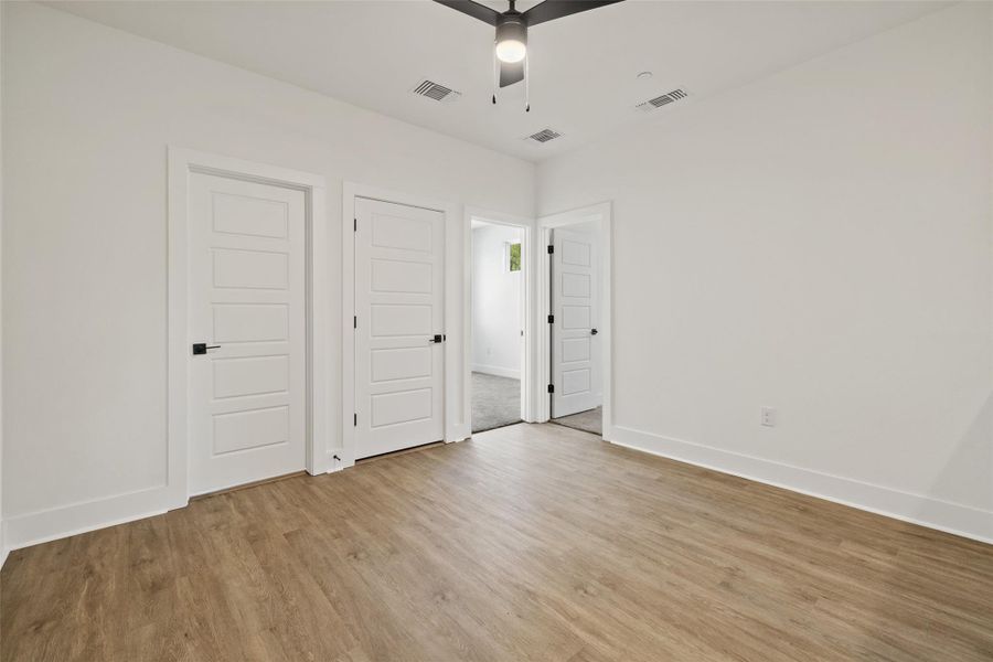Unfurnished bedroom featuring light wood-style flooring and ceiling fan Unfurnished bedroom featuring light wood-style flooring and ceiling fan