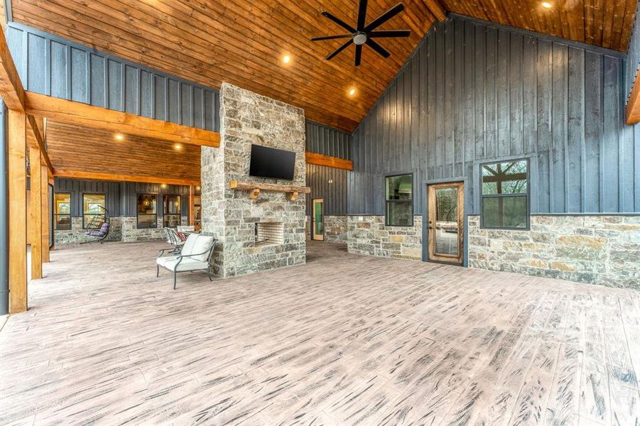 View of patio / terrace with ceiling fan and an outdoor stone fireplace