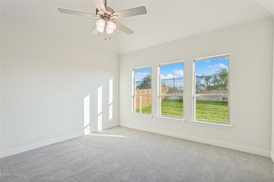 Carpeted spare room featuring ceiling fan