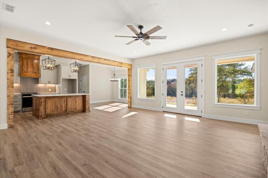 Living room featuring plenty of natural light, a chandelier, light wood finished floors, and recessed lighting