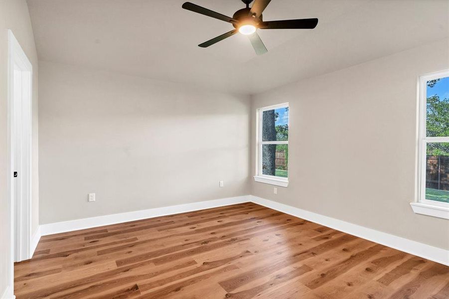 Empty room with wood finished floors and a ceiling fan Empty room with wood finished floors and a ceiling fan