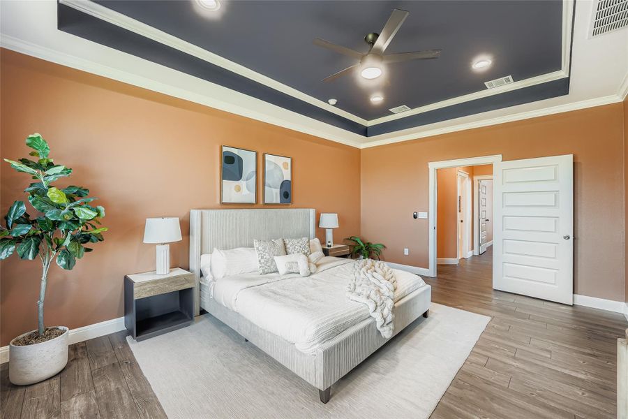 Bedroom featuring crown molding, a raised ceiling, ceiling fan, wood finished floors, and recessed lighting