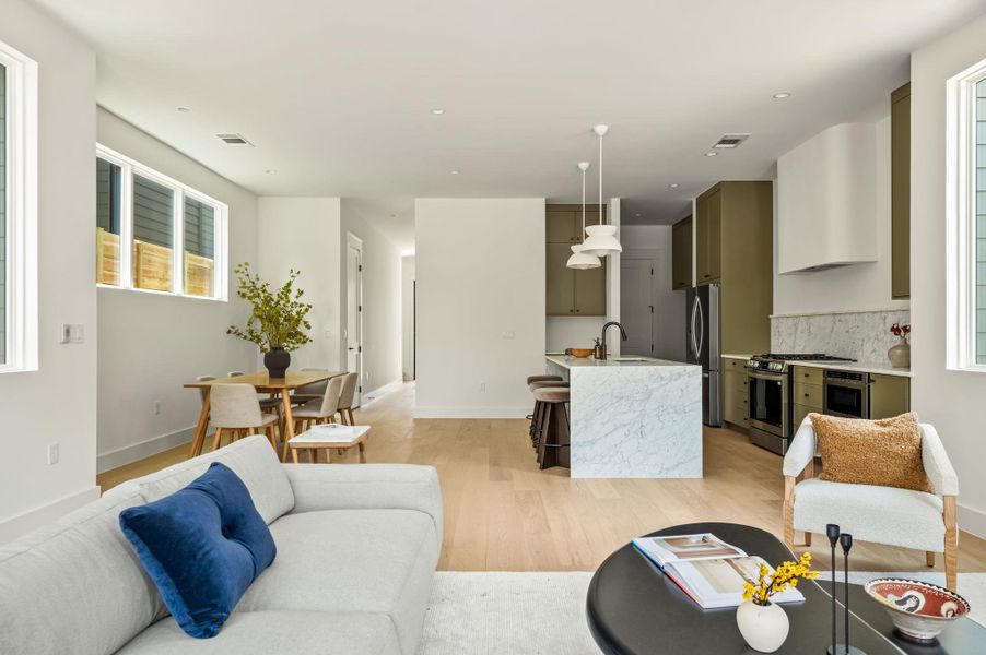 An open-concept living space integrates a stylish kitchen and dining area, featuring a waterfall island.