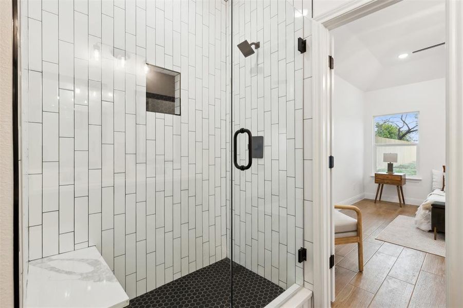 Bathroom featuring lofted ceiling and a shower with shower door