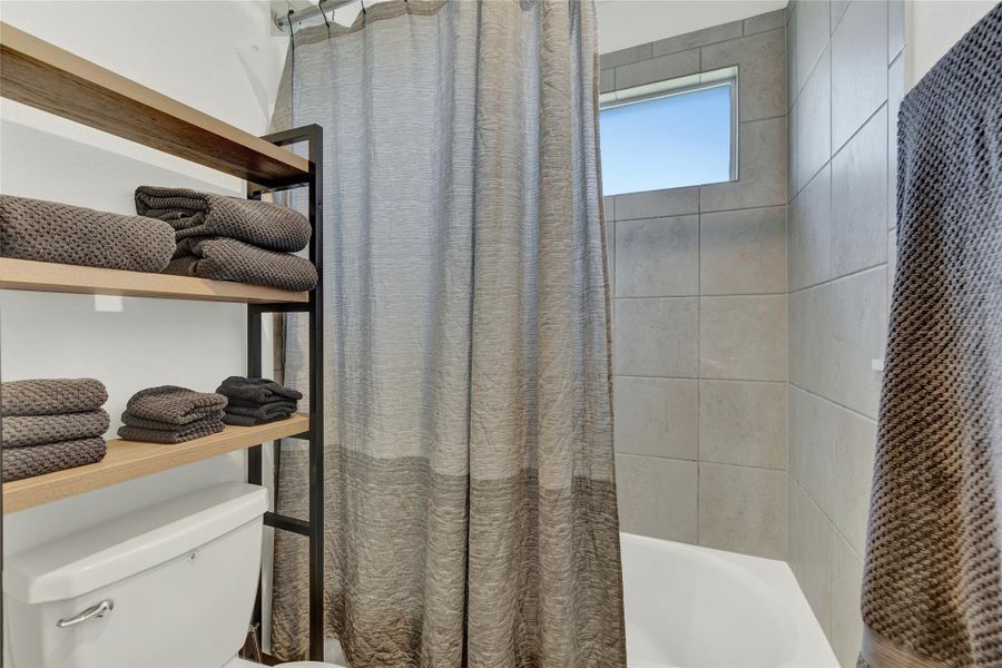 Minimalist bathroom design with integrated storage shelving for convenience.