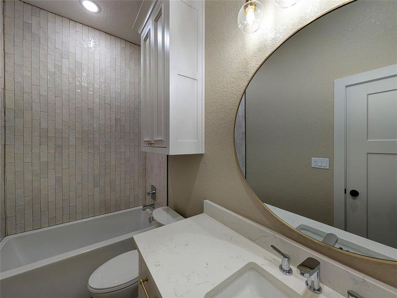 Full bathroom with bathing tub / shower combination, vanity, a textured wall, and recessed lighting