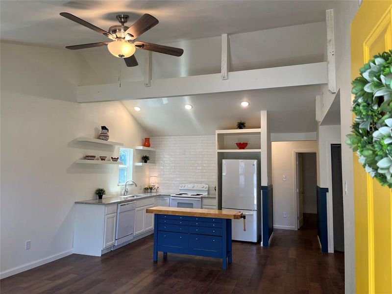 Vaulted ceilings featuring exposed beams and a ceiling fan with integrated lighting