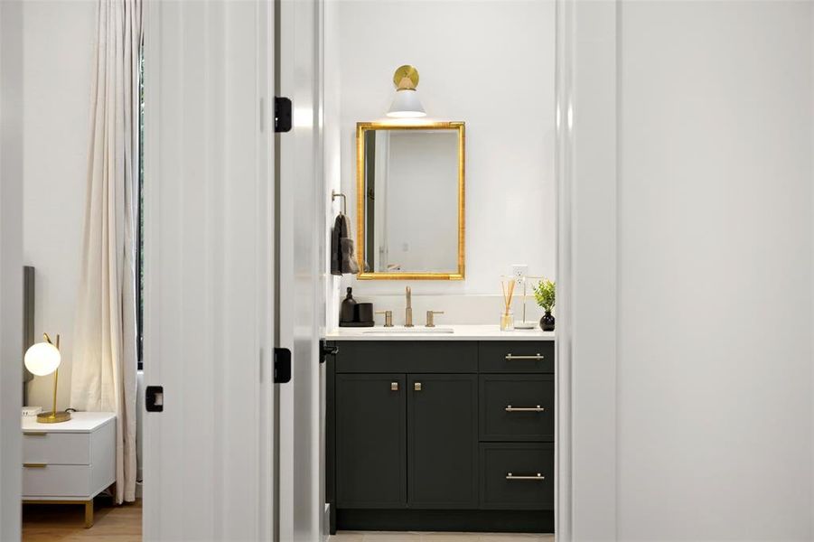 Bathroom vanity featuring a dark gray cabinet, white countertop, and brushed nickel faucet