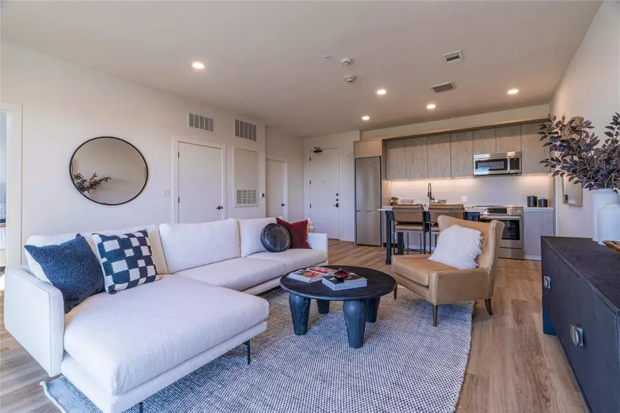 Living area featuring light wood-style flooring and recessed lighting.Photos shown are of a model residence and are representative in nature. Actual residence may differ in layout, finishes, and views.