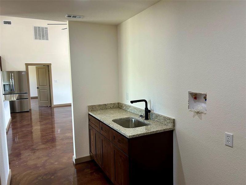 Washroom featuring a textured wall and a towering ceiling