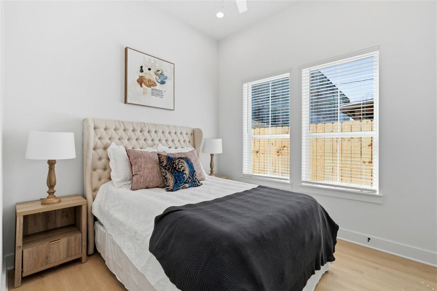 Duplex secondary bedroom with high ceilings, oversized windows, and great natural light.