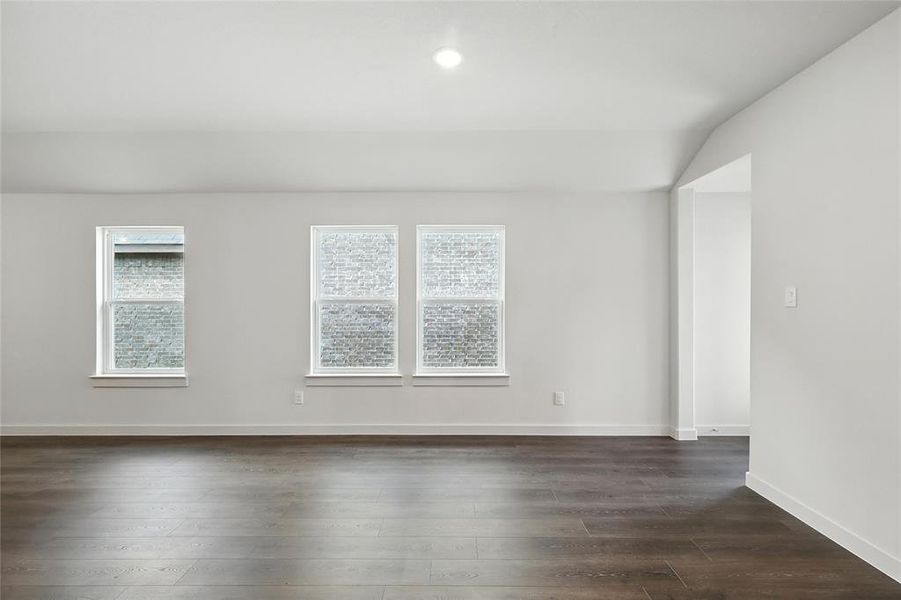 Spare room with dark wood-style floors, recessed lighting, and vaulted ceiling Spare room with dark wood-style floors, recessed lighting, and vaulted ceiling