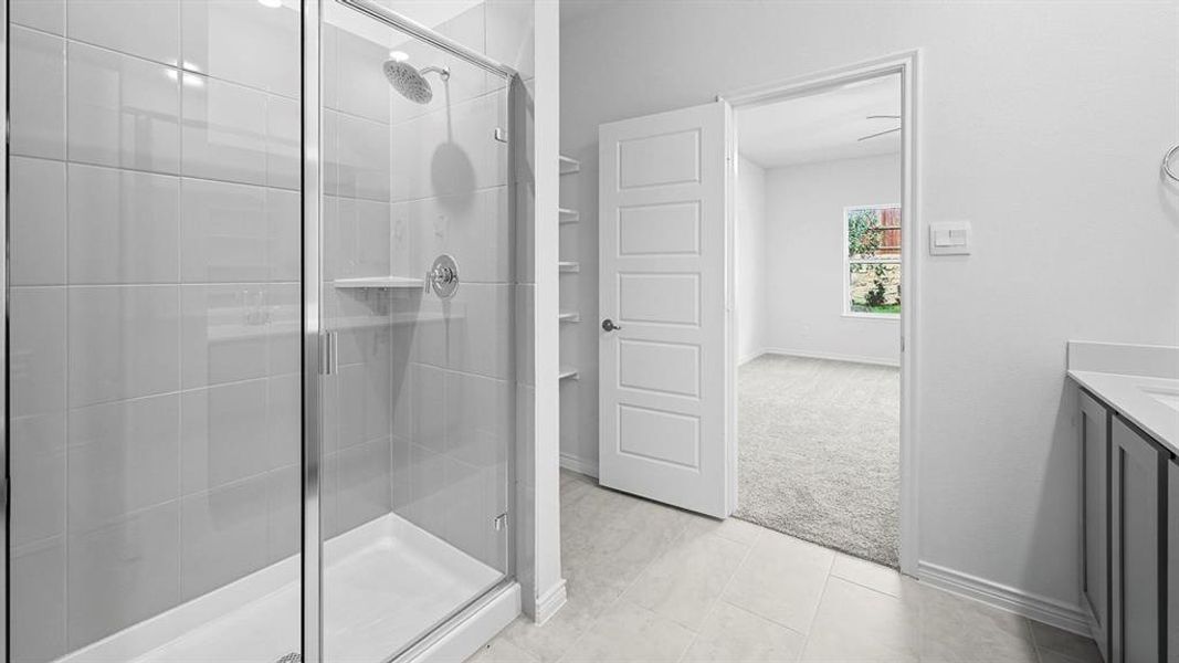 Full bath featuring vanity, a stall shower, and light colored carpet