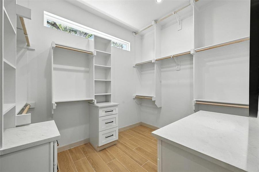 Spacious closet with light wood-style flooring Spacious closet with light wood-style flooring