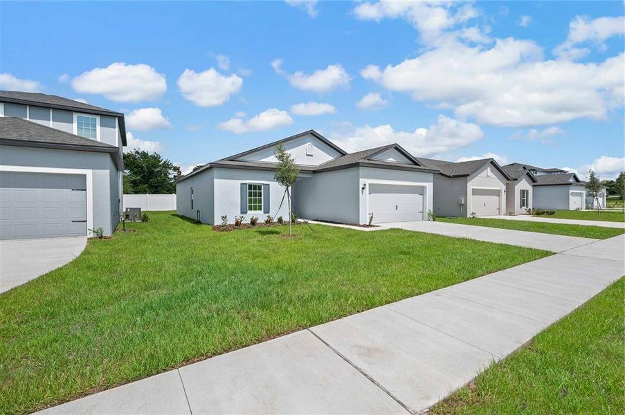 Front exterior of a new home in Tula Parc, Astatula, FL, highlighting curb appeal (Image 14).