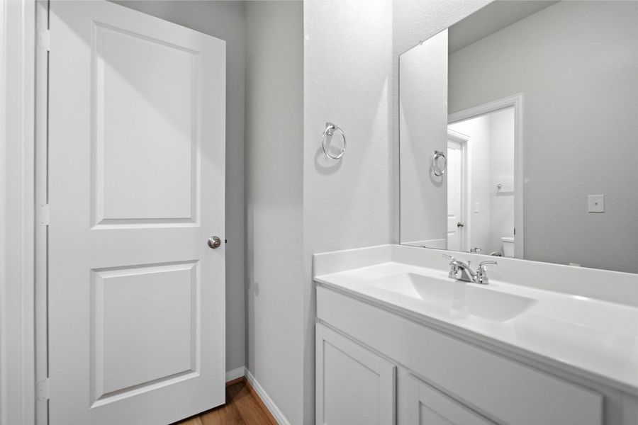 Half bathroom featuring vanity and light wood-type flooring