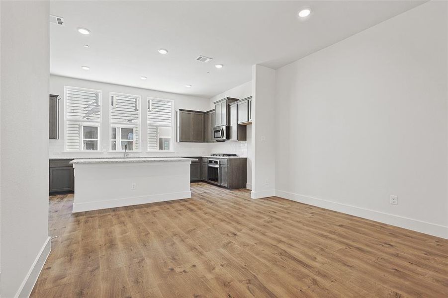 Kitchen featuring stainless steel appliances, a kitchen island, light hardwood / wood-style floors, and sink