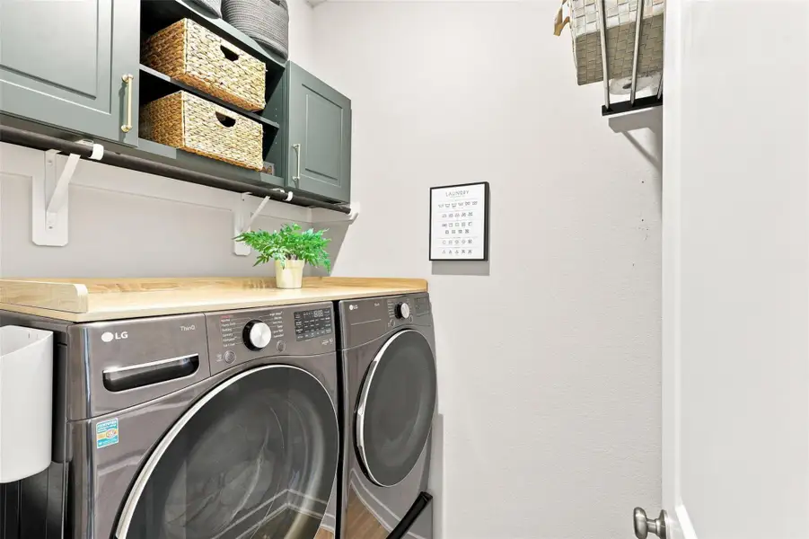 Laundry room on first floor with built-in storage and hanging rods