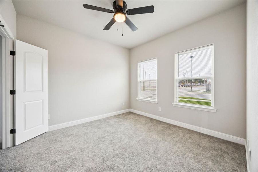 (Bedroom #2) bedroom featuring light colored carpet, walk-in closet and a ceiling fan