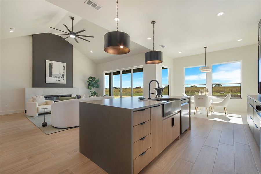 Kitchen with a kitchen island with sink, open floor plan, pendant lighting, wood tiled floors, and recessed lighting Kitchen with a kitchen island with sink, open floor plan, pendant lighting, wood tiled floors, and recessed lighting