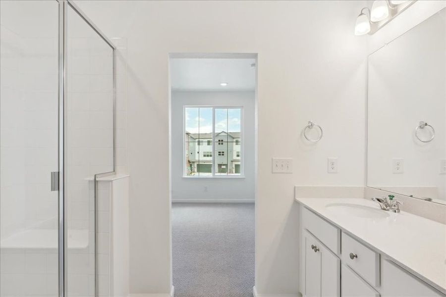 A bathroom with a sink and a shower unit.