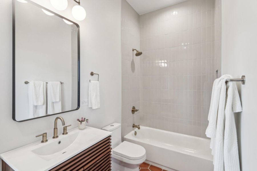 Full bathroom featuring toilet, vanity, and shower / tub combination Full bathroom featuring toilet, vanity, and shower / tub combination