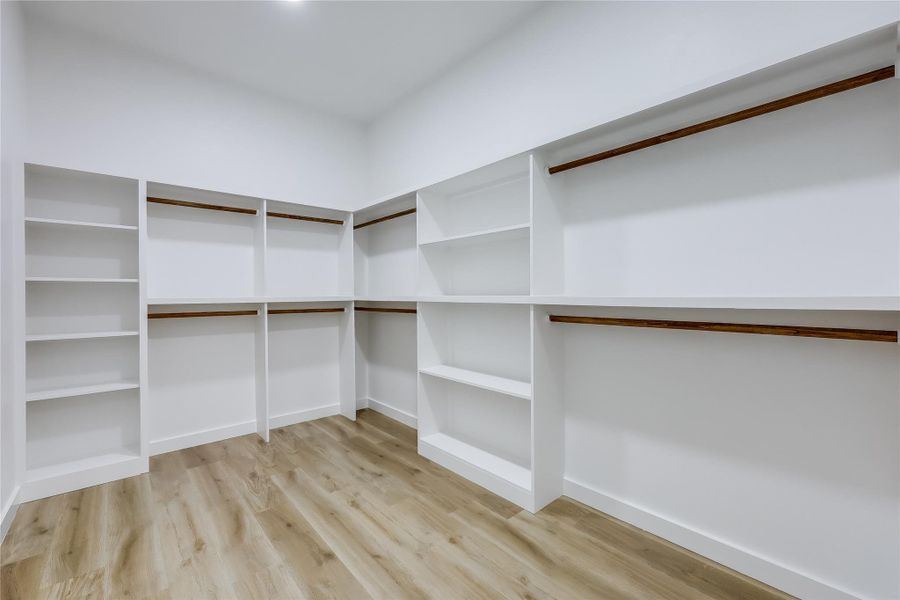Walk in closet featuring light wood finished floors Walk in closet featuring light wood finished floors