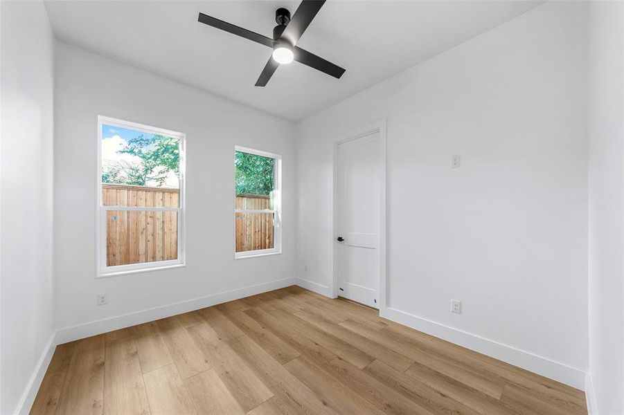 Empty room featuring light wood-type flooring and a ceiling fan Empty room featuring light wood-type flooring and a ceiling fan