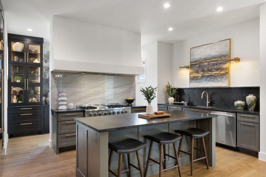 A sleek kitchen island provides casual seating, complemented by modern appliances and sophisticated finishes.