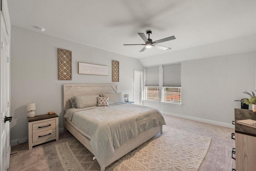 Bedroom with carpet, vaulted ceiling, and a ceiling fan
