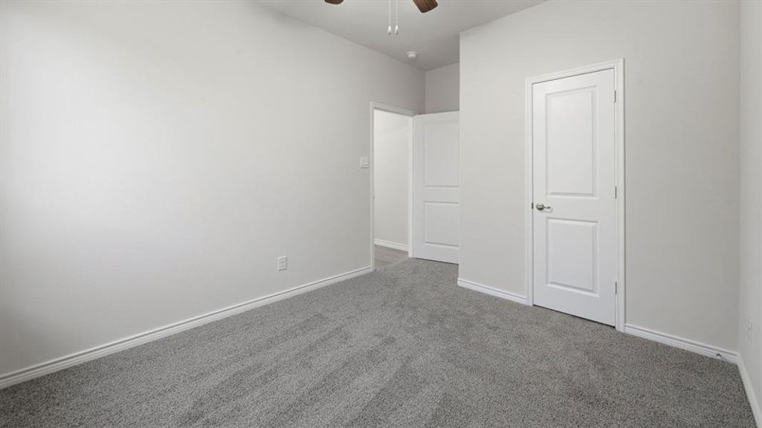 Unfurnished bedroom with carpet and a ceiling fan Unfurnished bedroom with carpet and a ceiling fan
